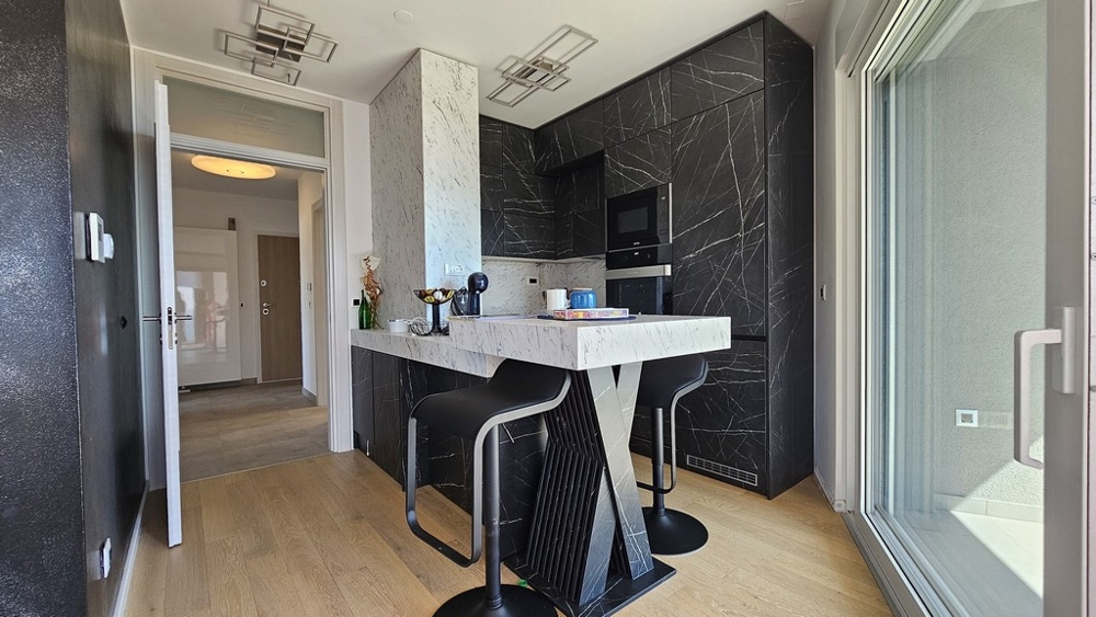 Modernt kök med svart design och barstolar