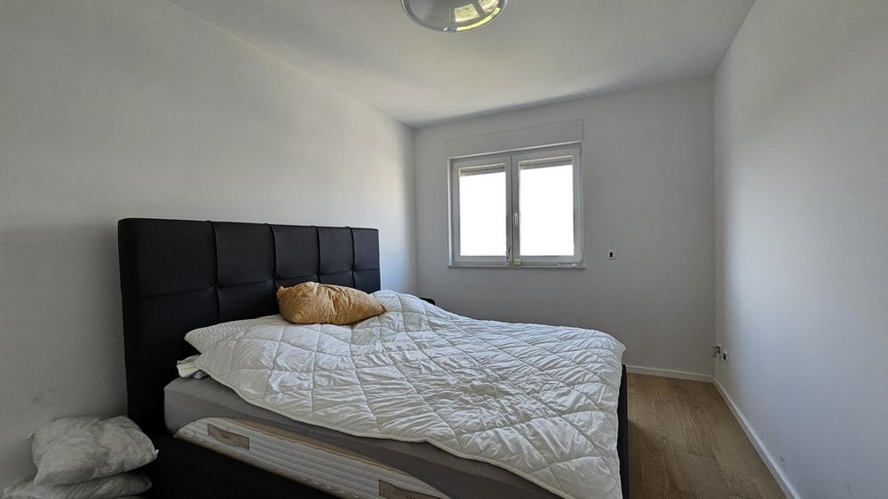 Sovrum med stor säng och vitt täcke