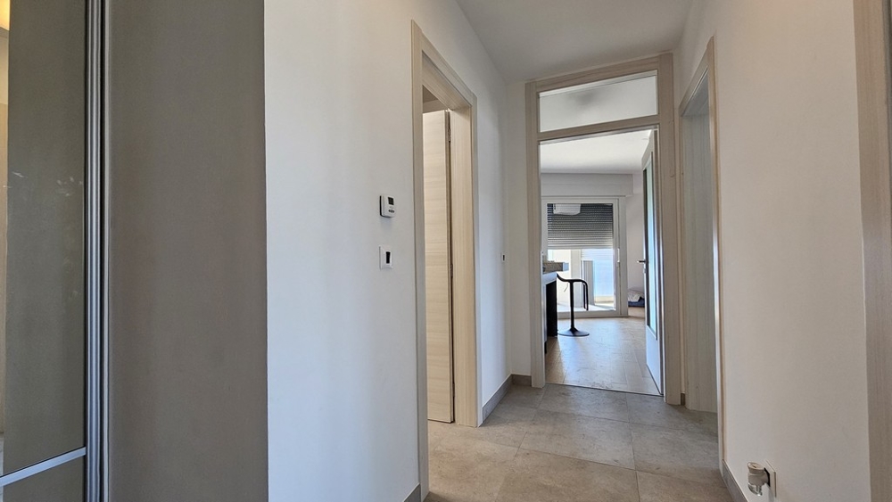 Hall med utsikt över kök och dörrar till rum