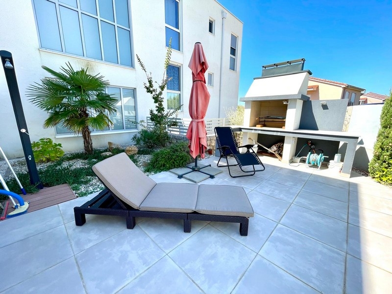 Sommarkök och solplats samt utomhusdusch i fastighetens privata uteplats.