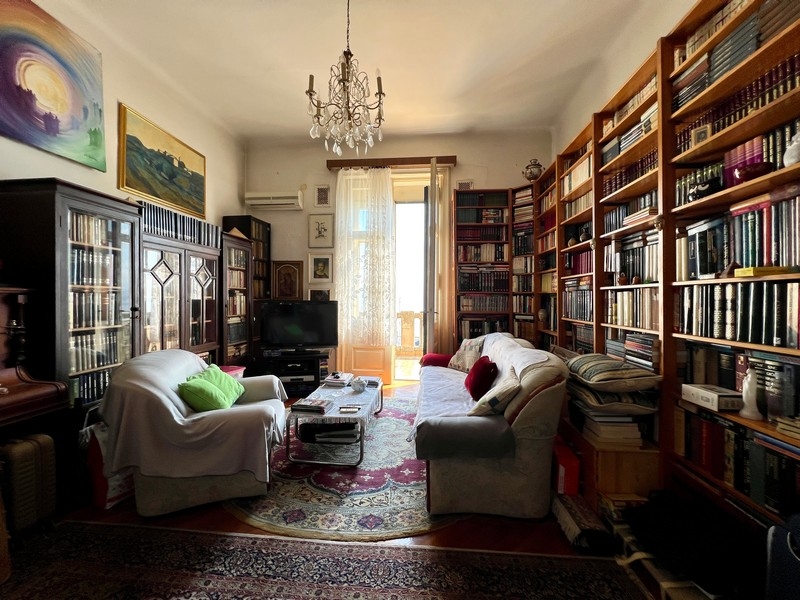 Lägenhet med stora och höga bokhyllor.