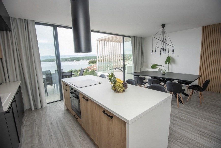 Modernt kök med matbord och havsutsikt.