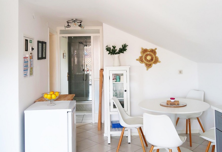 Utsikt över matsalen med ett elegant bord. Bakgrund: badrum.