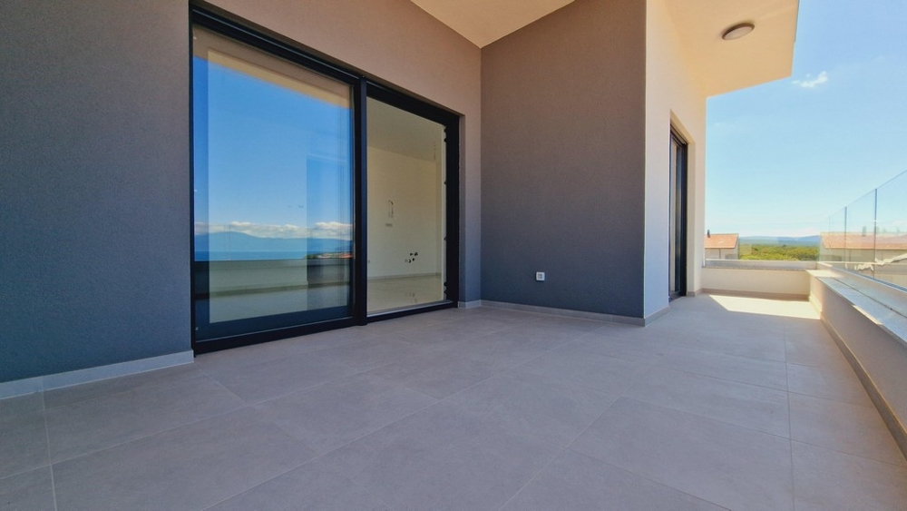 Terrass med klinkergolv och glasräcken, utsikt över havet och omgivningarna