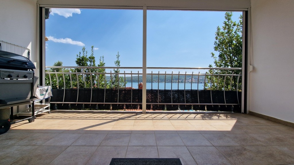 Terrass med havsutsikt och grill.