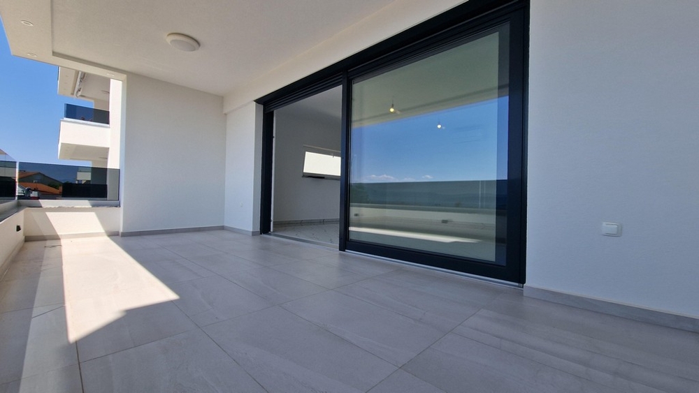 Täckt terrass på första våningen med utsikt över havet.