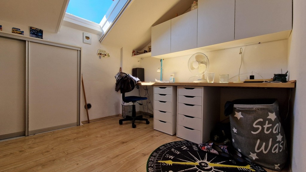 Arbetsrum med skrivbord och förvaringsutrymme under takfönstret