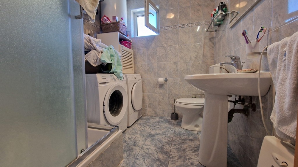 Badrum med tvättmaskin och dusch