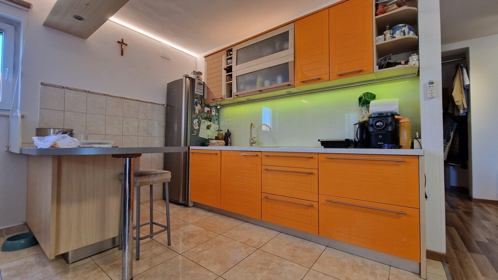 Modernt kök med orange fronter och matplats