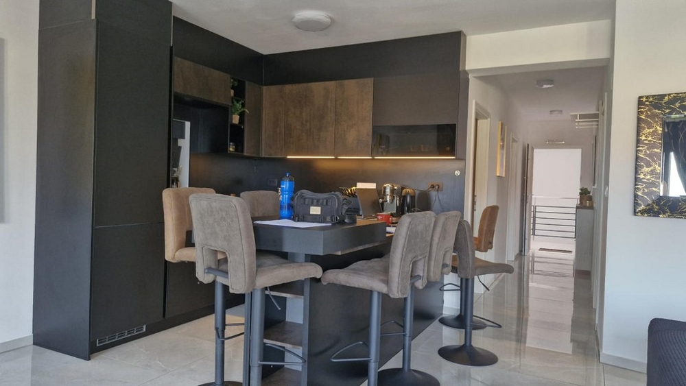 Modernt kök med barstolar och matbord