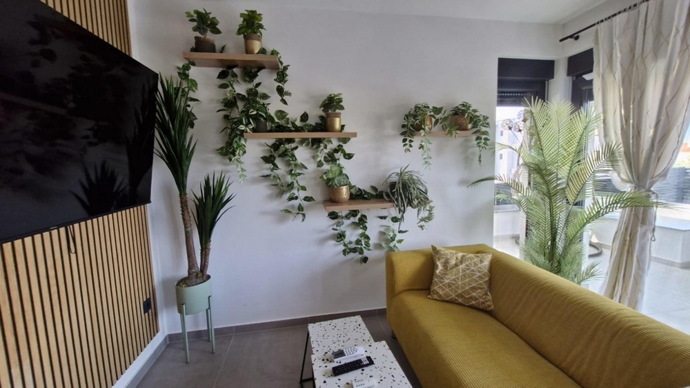 Vardagsrum med soffa (gul) och TV.