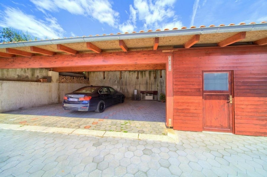 Täckt parkeringsplats med en parkerad bil och träpanel