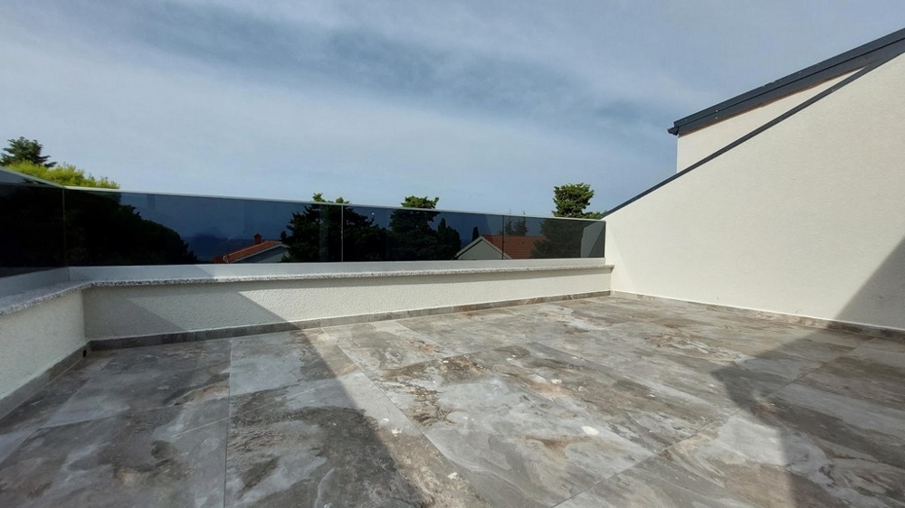 Lägenheten har en öppen och rymlig terrass med havsutsikt.