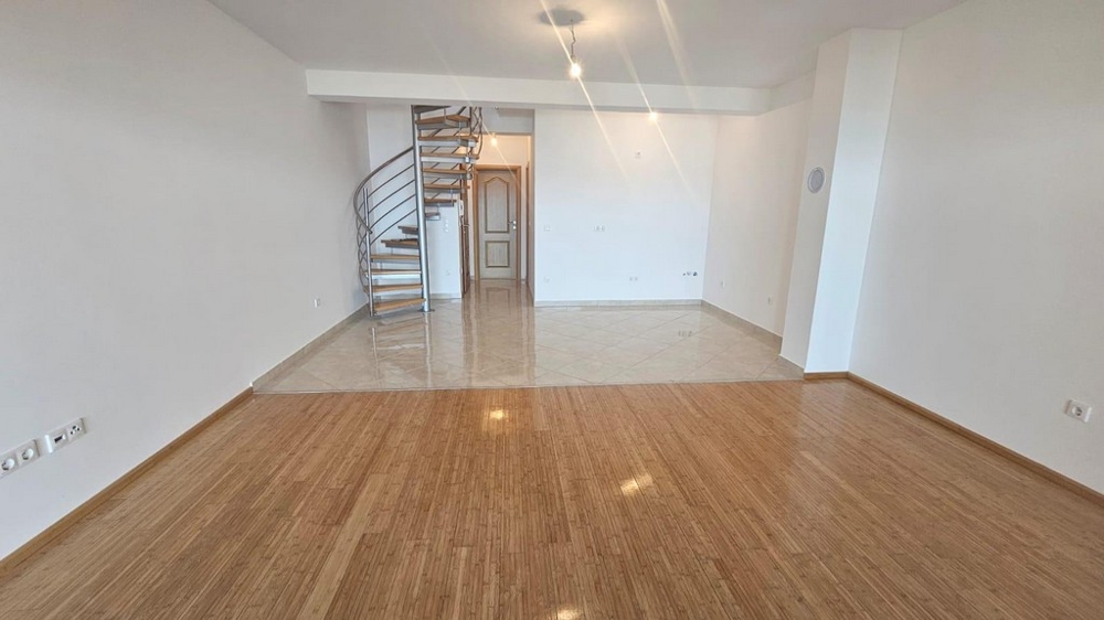 Stort vardagsrum med spiraltrappa och kaklad yta