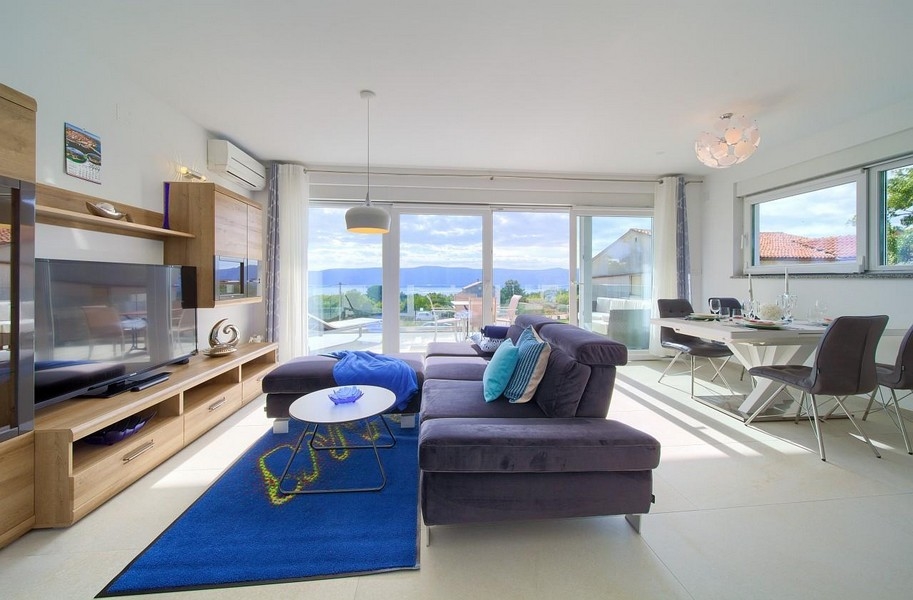 Modernt inrett vardagsrum och utsikt över havet.