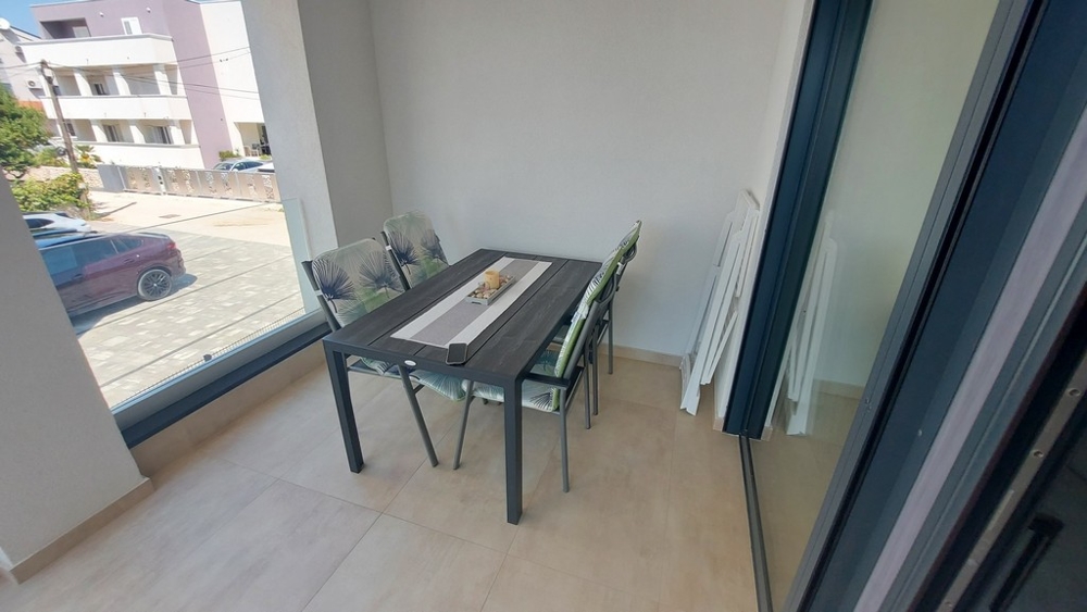 Täckt terrass och utsikt över parkeringsplatsen för fastighet A3448.