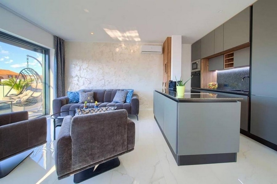 Högkvalitativ lägenhet med ett modernt kök och utsikt över terrassen.