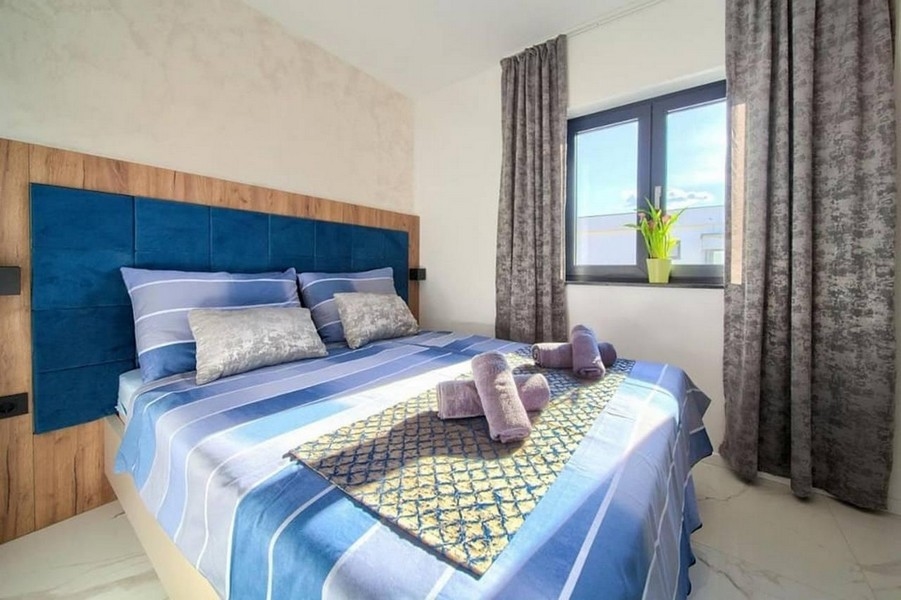 Modernt sovrum med stor säng och fönster