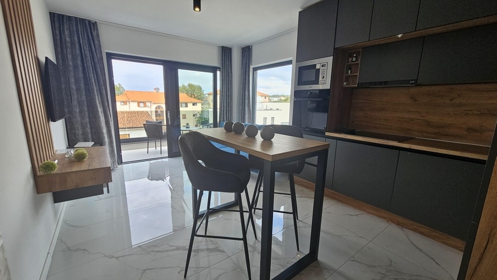 Öppet kök och matplats med balkong och stort fönsterfront