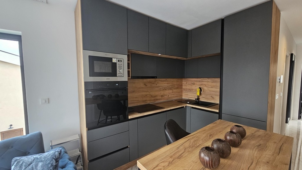 Modernt kök med inbyggda vitvaror och matbord