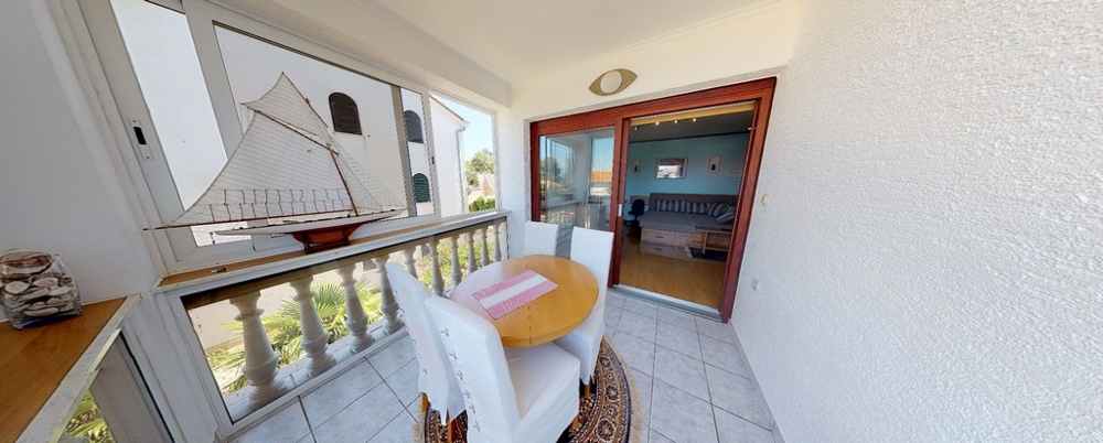 Terrassen och utsikten över vardagsrummet i semesterlägenheten A3458, som säljs i Kroatien.