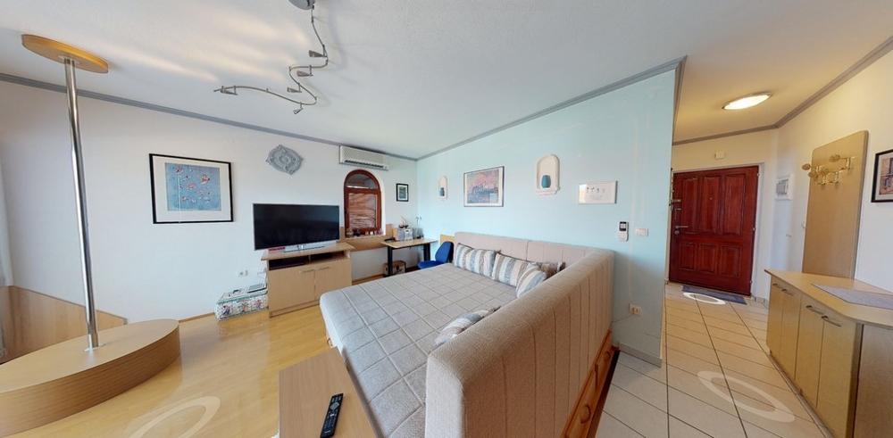 Vardagsrummet med en bekväm soffa och en TV.