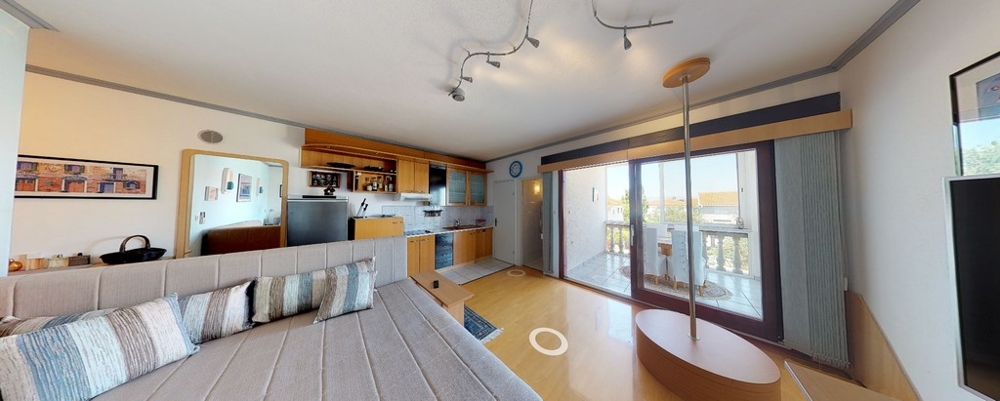 Vardagsrum med utsikt över det funktionella köket i fastighet A3458.