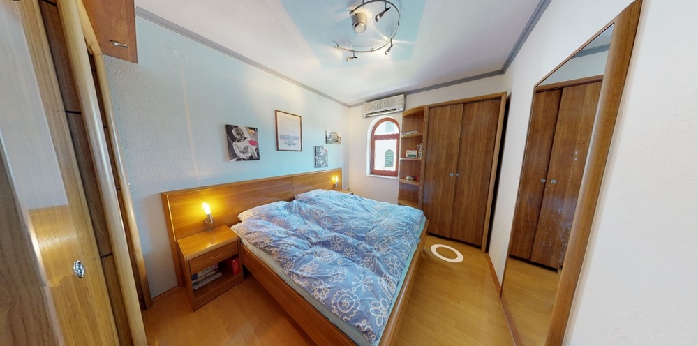 Mysigt sovrum med fönster, dubbelsäng och garderob - fastighet A3458.