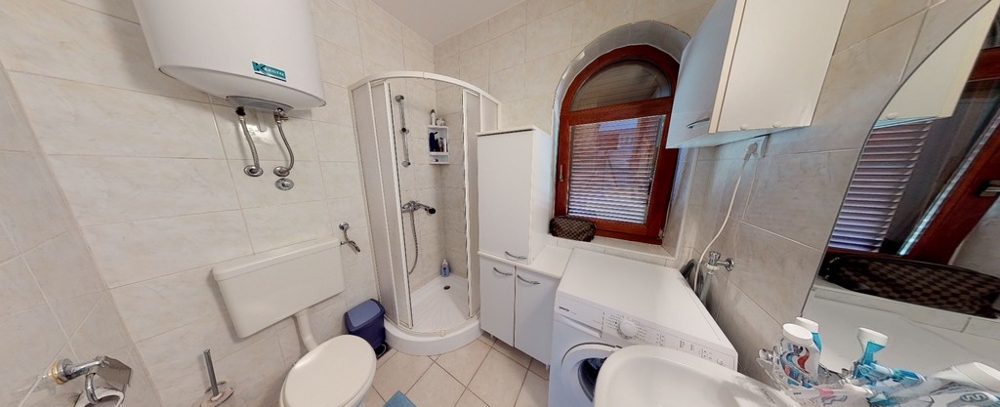 Ljust badrum med fönster och dusch.