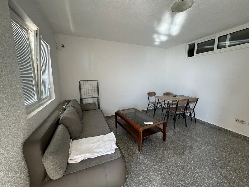 Vardagsrum med soffa och matbord.