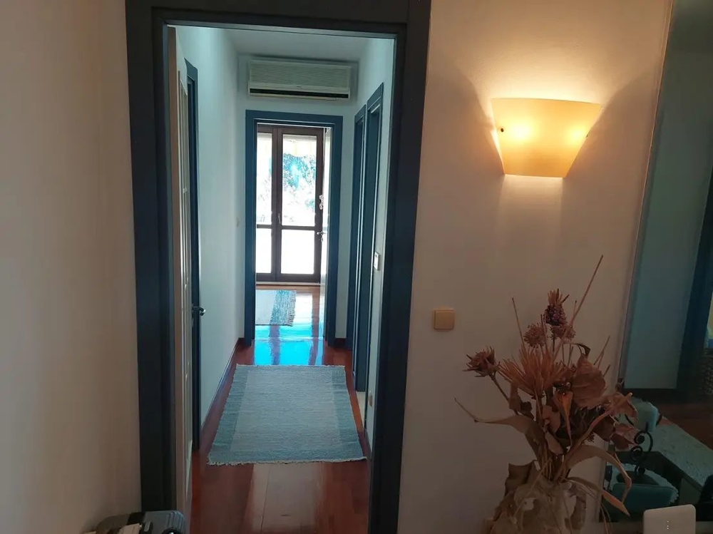 Hall med ljusa väggar och trägolv, modernt inredd entrédel