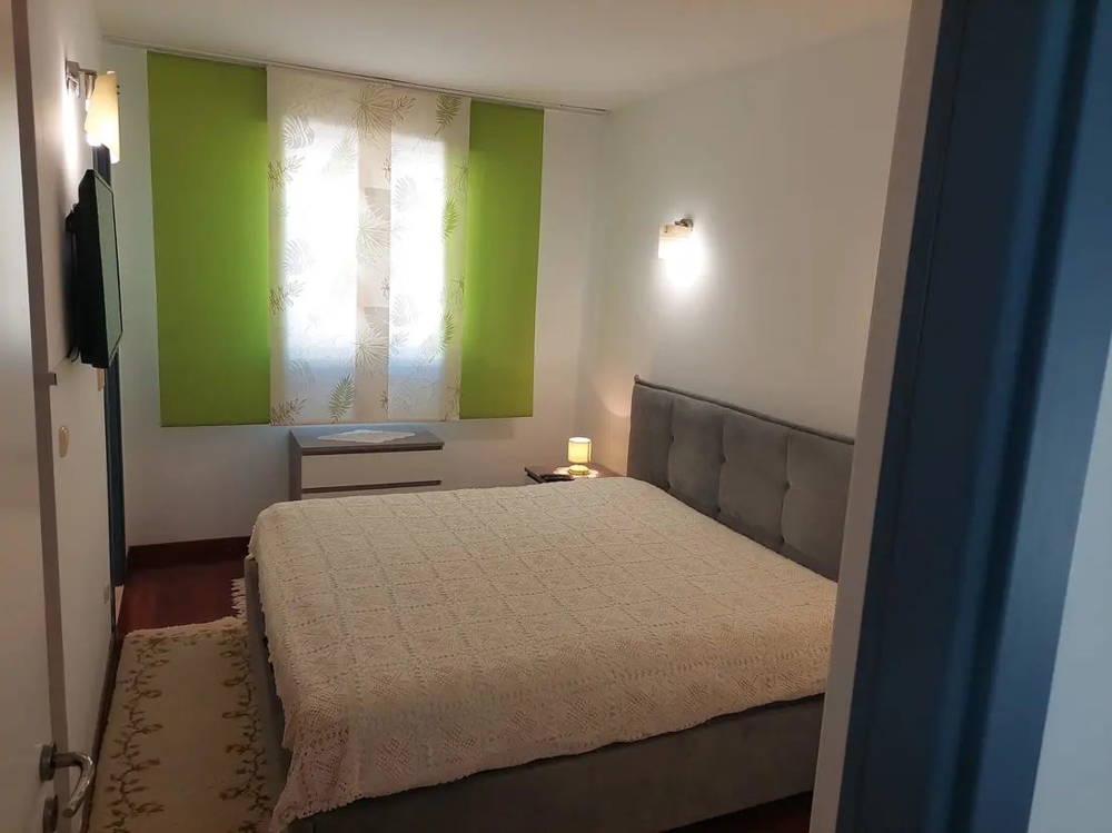 Sovrum med stor säng och gröna gardiner