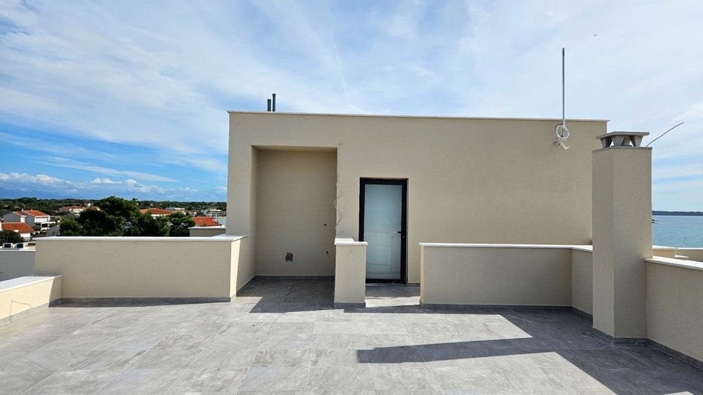 Takterrass med ingångsdörr som leder till ett täckt område