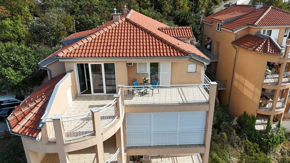 Exteriör vy av en byggnad med flera balkonger och ett rött tegeltak