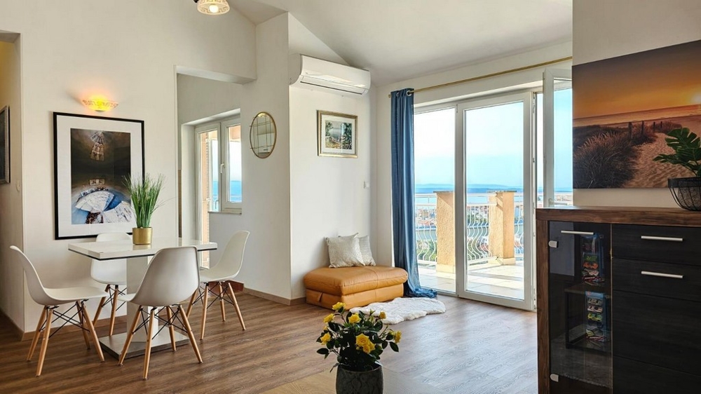 Vardagsrum med stort fönster och terrass