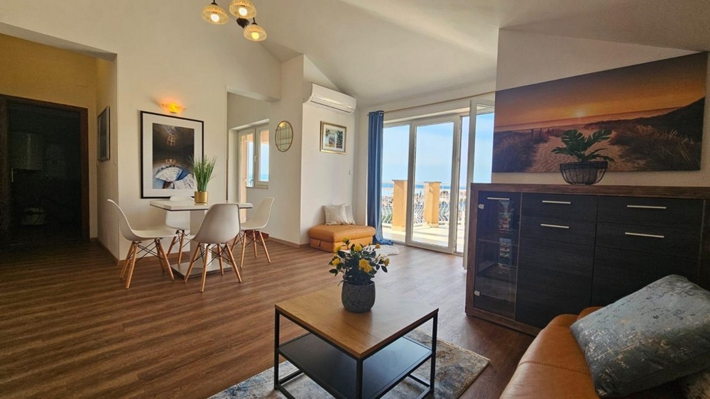 Vardagsrum med matplats och utgång till terrassen, dekorerad med växter och väggmålningar