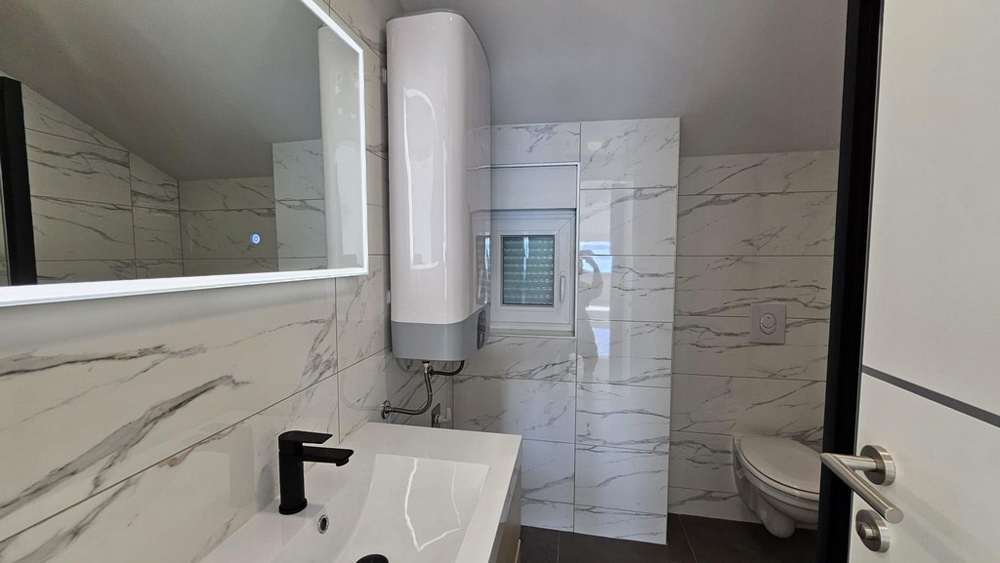 Badrum med spegel, handfat och toalett