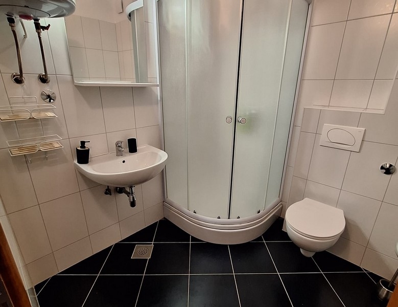 Modernt badrum med duschkabin, handfat och toalett