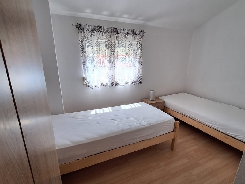 Sovrum med två enkelsängar och ljusa gardiner