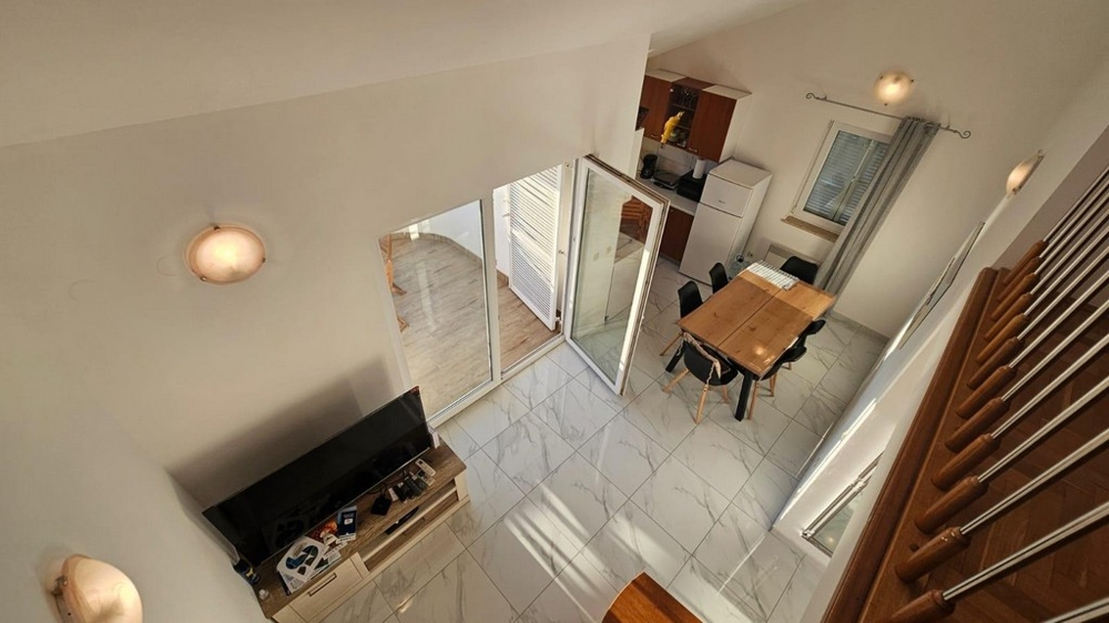 Utsikt från galleriet över vardagsrummet och matsalen.