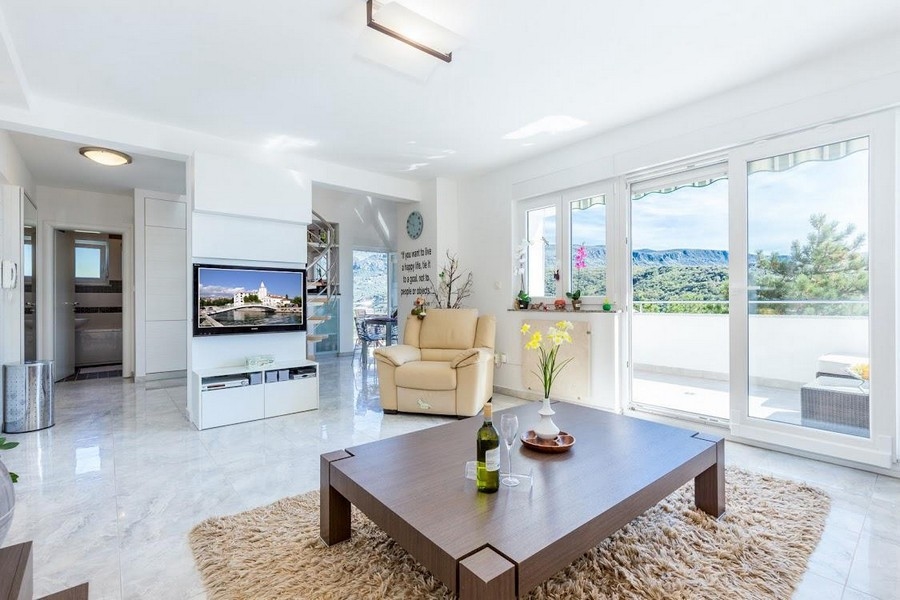 Vardagsrum med stort fönster och modern inredning