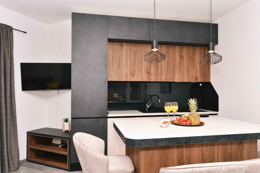 Stilrent kök med träfronter, modern design och rymlig arbetsyta.