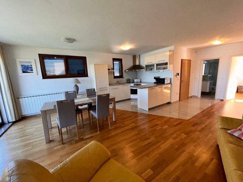 Kök och matplats i öppen planlösning med utsikt över vardagsrummet