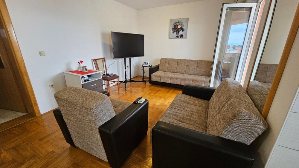 Möblerat vardagsrum med tillgång till terrassen till lägenheten till salu i Malinska (Kroatien).