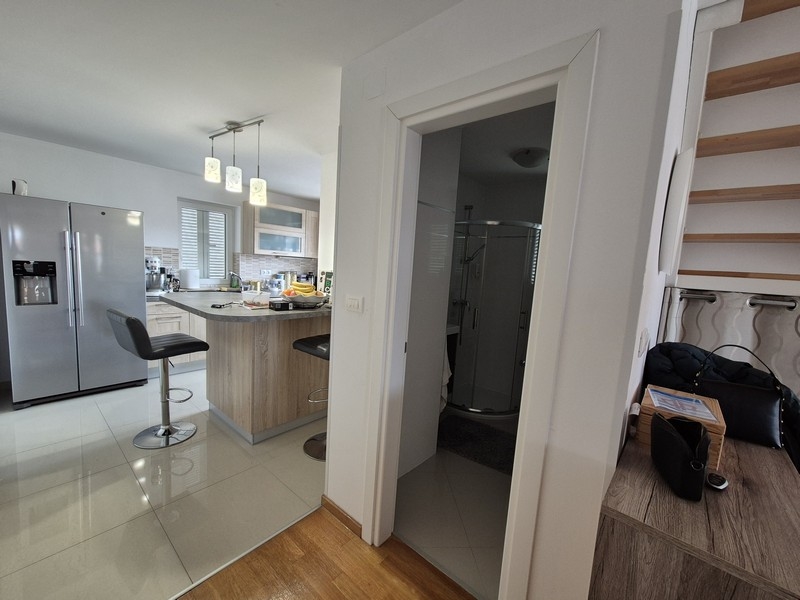 Öppet kök med ö, barstolar och tillgång till badrummet