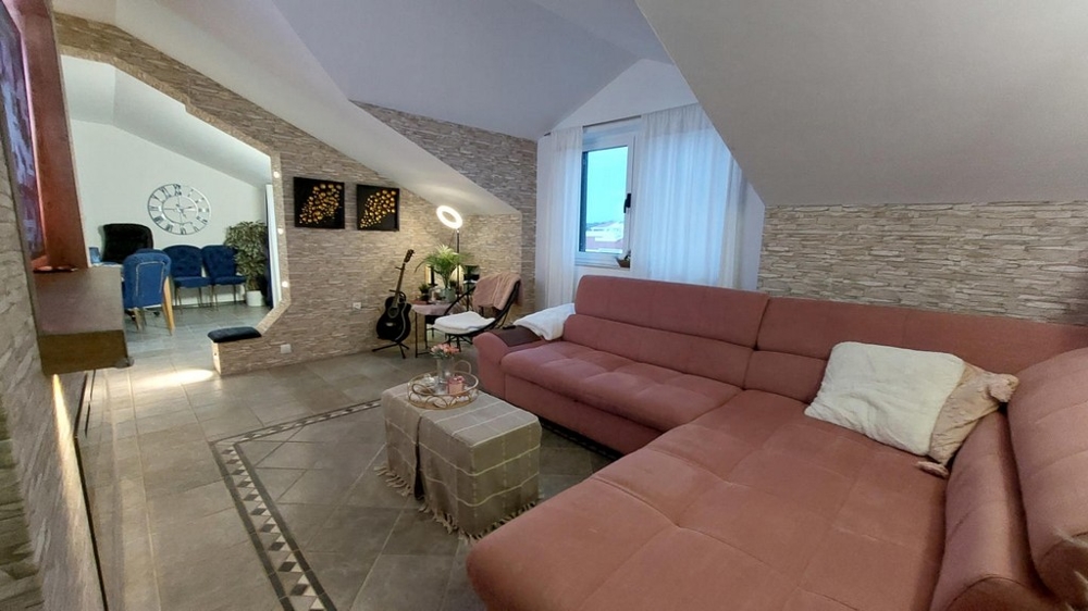 Rymligt vardagsrum med soffa och utsikt över matbordet.