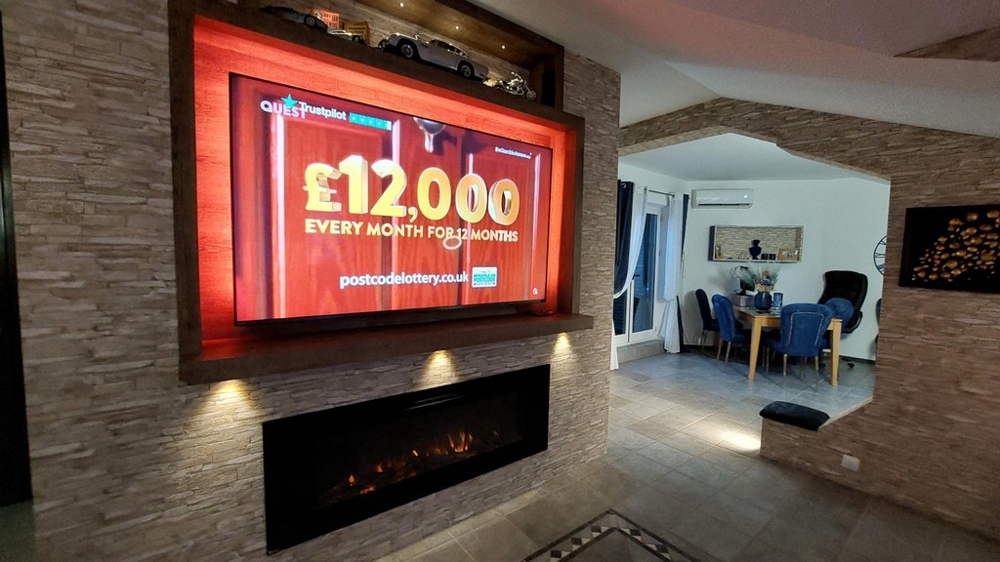 Ljust vardagsrum med öppet kök och smart-tv