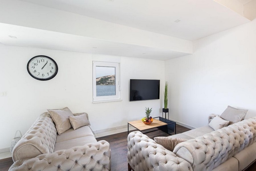 Vardagsrum med havsutsikt och TV.