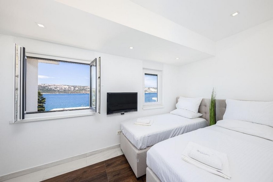 Sovrum med två enkelsängar och vacker havsutsikt.