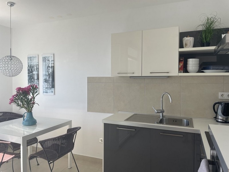 Ljust kök med matbord och inredning